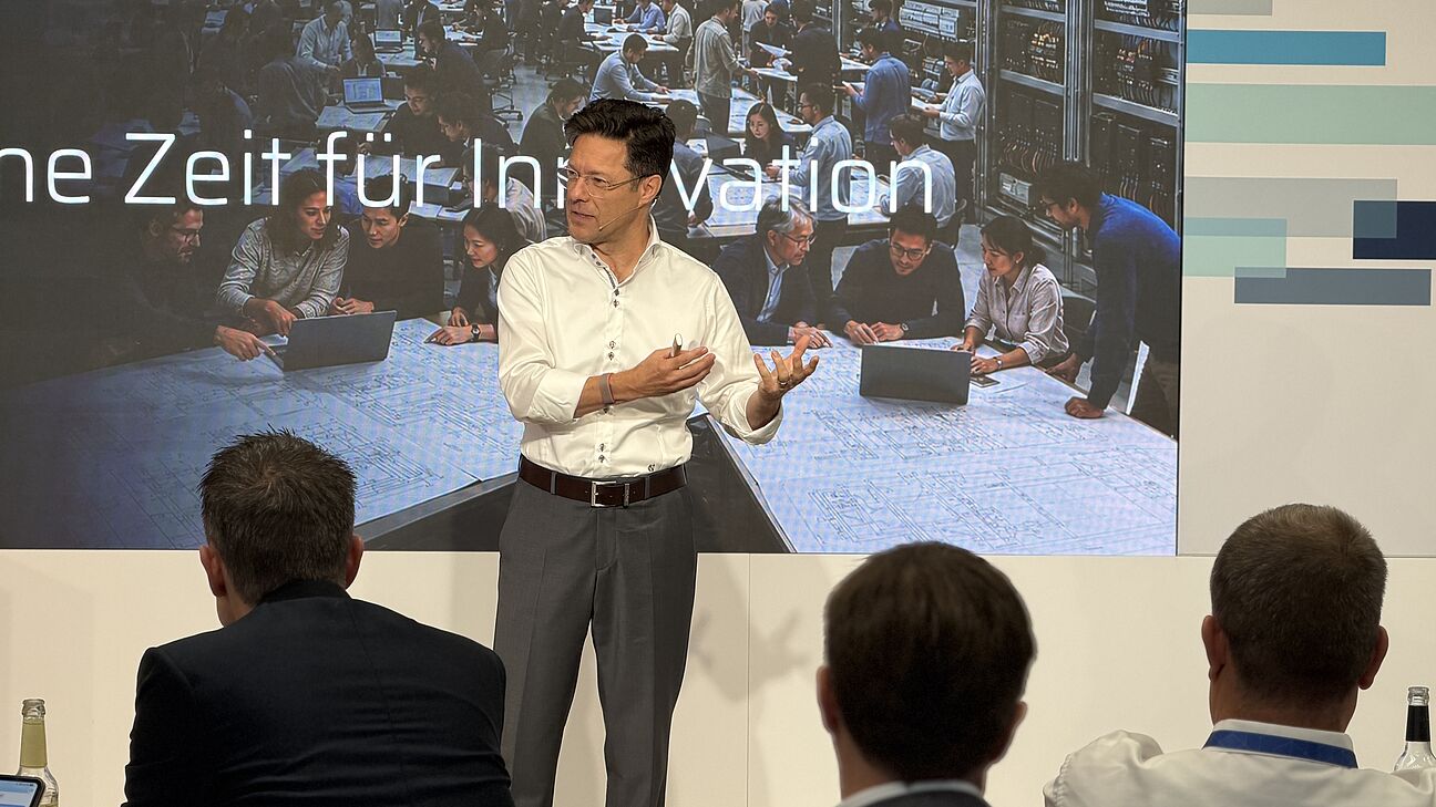 Automation Next Conference 2026 - Axel Zein steht auf der Bühne und spricht zum Publikum