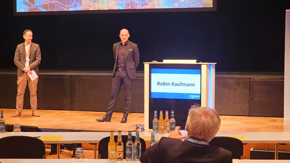 Automation Next Conference 2025 - Robin Kaufmann auf der Bühne Richtung Teilnehmer und beantwortet eine Frage  