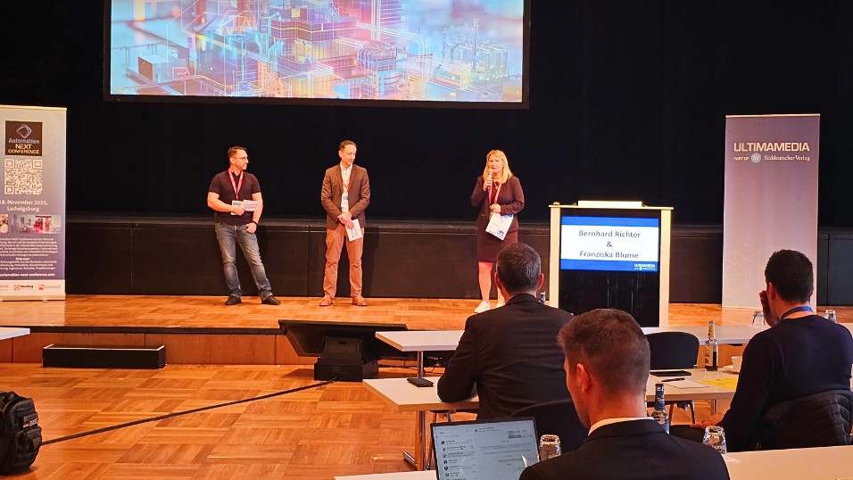 Automation Next Conference 2025 - Begrüßung der Veranstalter auf der Bühne und schauen Richtung Teilnehmer. 
